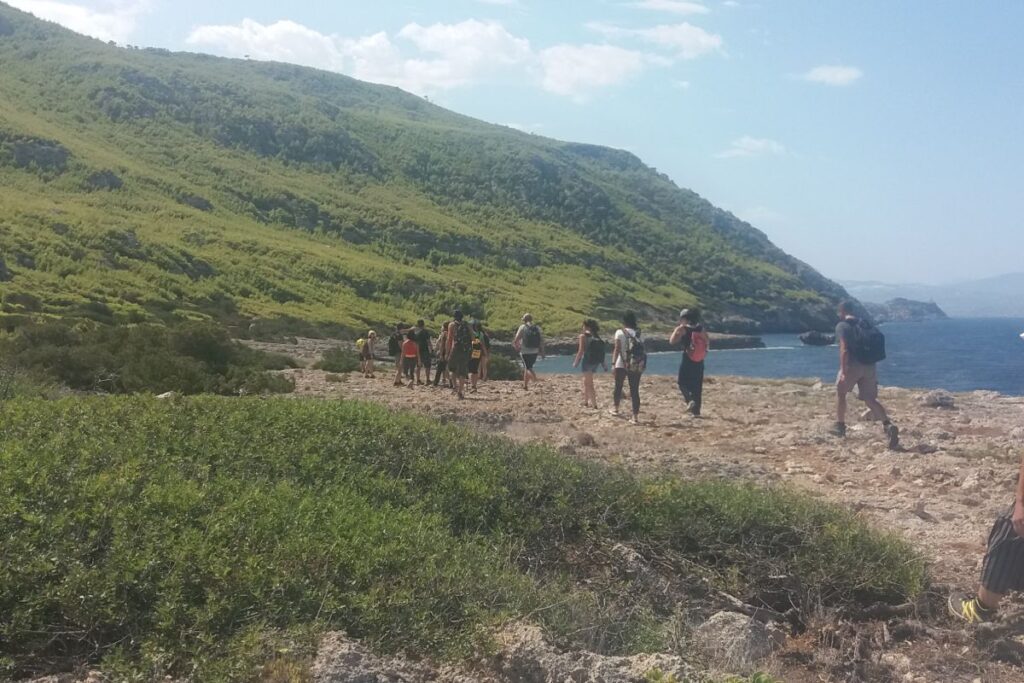 Things to Do in Loutraki Greece, with a group of hikers near the seaside.