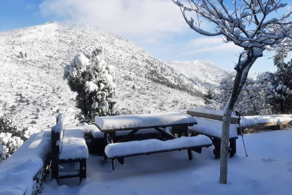 Hike Safely in Greece, Wooden benches on a mountain covered in snow