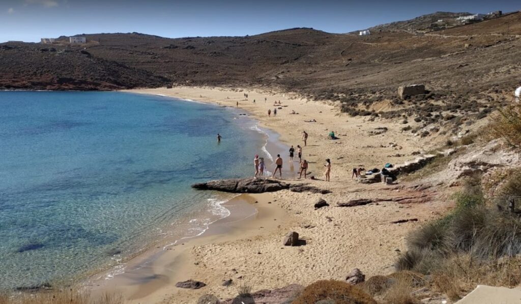 Sandy beach and people in Agios Sostis Fransesco Bisigniano in Mykonos Island.