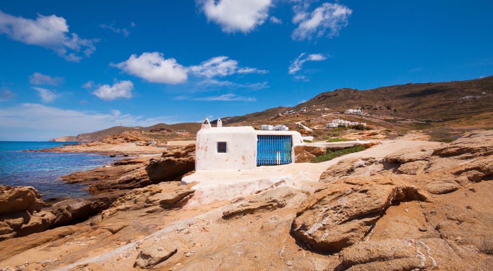 A whitewashed building on Ftelia Beach with blue Sky in Mykonos Island.