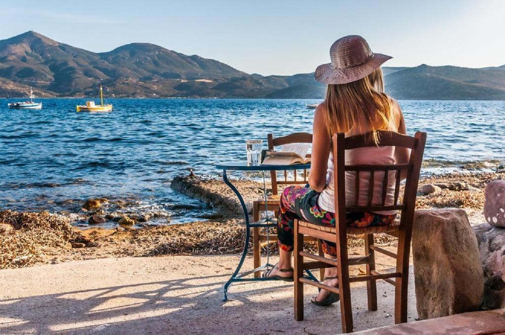 Young woman sitting in front of sea in Milos island.