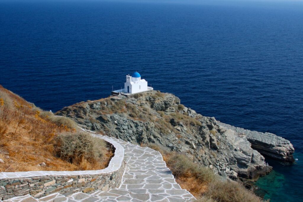 Hiking Cyclades Islands, remote beautiful chapel by the sea in Sifnos island.  Hiking Cyclades islands.