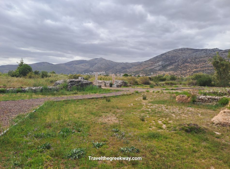 Ancient ruins and grassy field at the Sanctuary of the Egyptian Gods with mountains in the distance.
