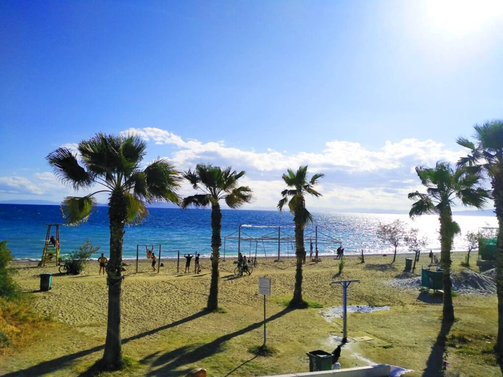 Athens Riviera. The Edem Beach in Paleo Faliro with palm trees and people at the playground