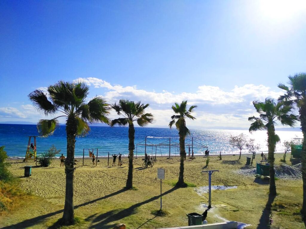 Athens Riviera. The Edem Beach in Paleo Faliro with palm trees and people at the playground.