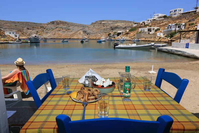 A traditional tavern table with food and ouzo at Sifnos Greece at a seaside village