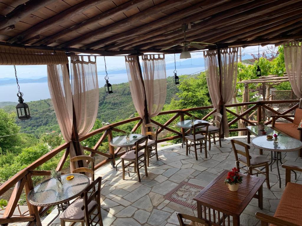 Some tables an chairs in a balcony with view to the sea in Iliovolo Guesthouse Terrace in Pelion Greece.
