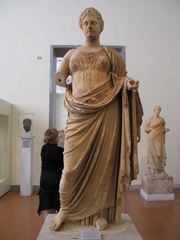Goddess Themis and a woman beside the statue in Ramnous Archaeological Site in Athens. 