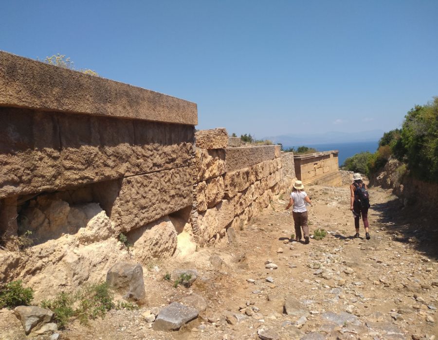 Two women walking in a sunny day in Ramnous Archeological Site in Athens.