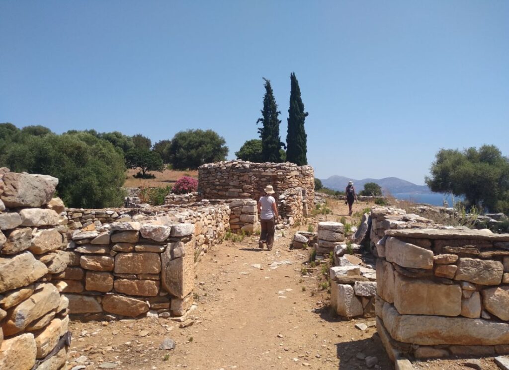 Two people walking on the main road in Ramnous Archaeological site in a sunny day in Athens Greece.