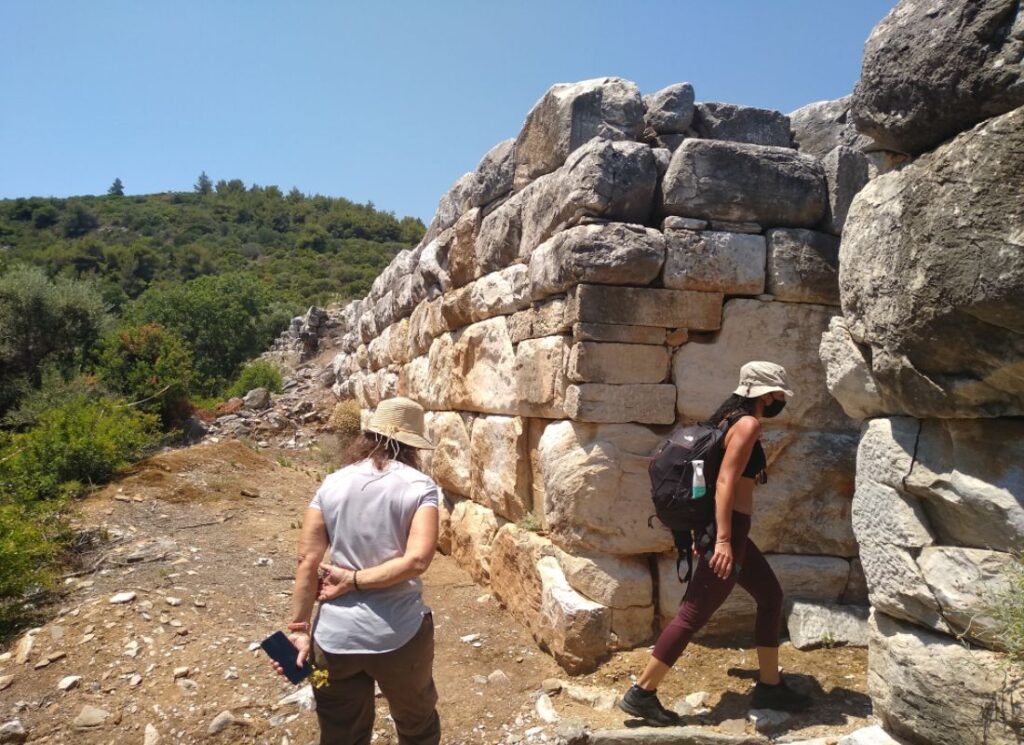 Two women entering the walls of Ramnous Archaeological Site in Athens.