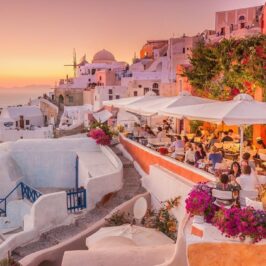 Oia Santorini in sunset with people sitting in restaurants