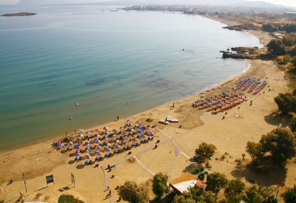 A sandy beach called Chrysi Akti with many people under umbrellas in Chania Crete Greece.