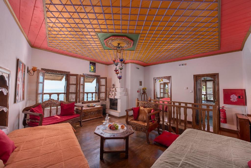 Archontiko hotel with chairs, sofas, coffee table and a fire place in Pelion Greece.