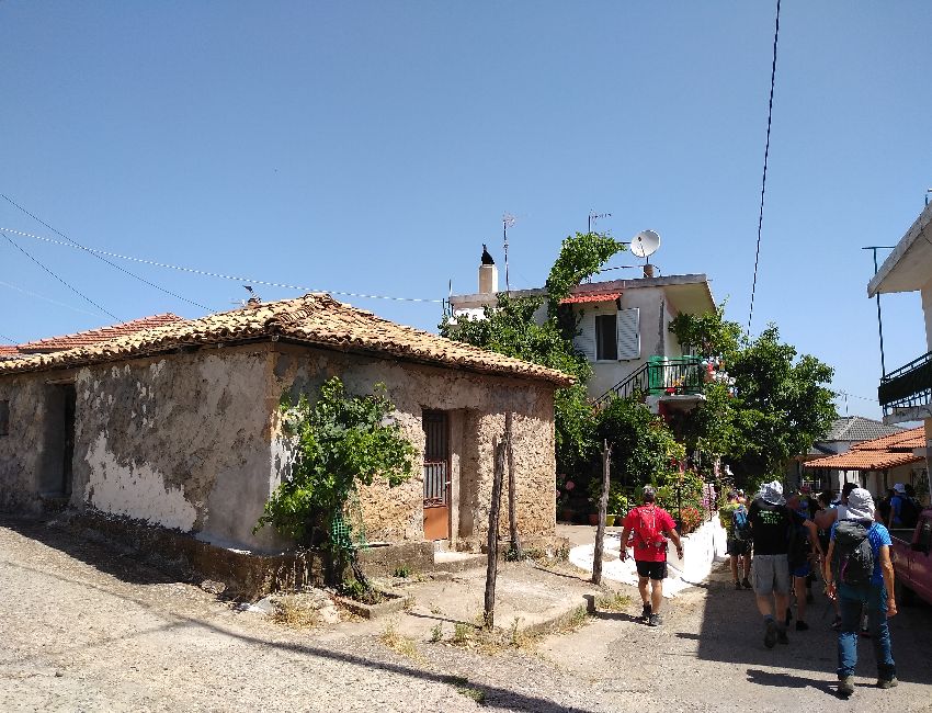 Nemouta Village, three houses and some people walking in a sunny day in Nemouta Water falls in Ancient Olympia Greece.