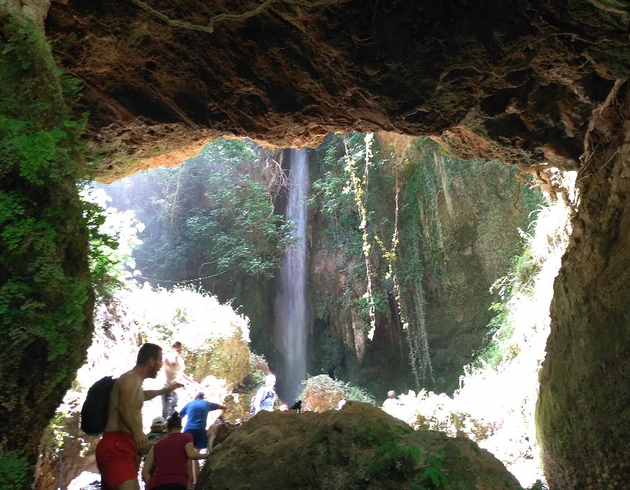 The gate to the water fall and some people in Nemouta Water falls in Ancient Olympia Greece.