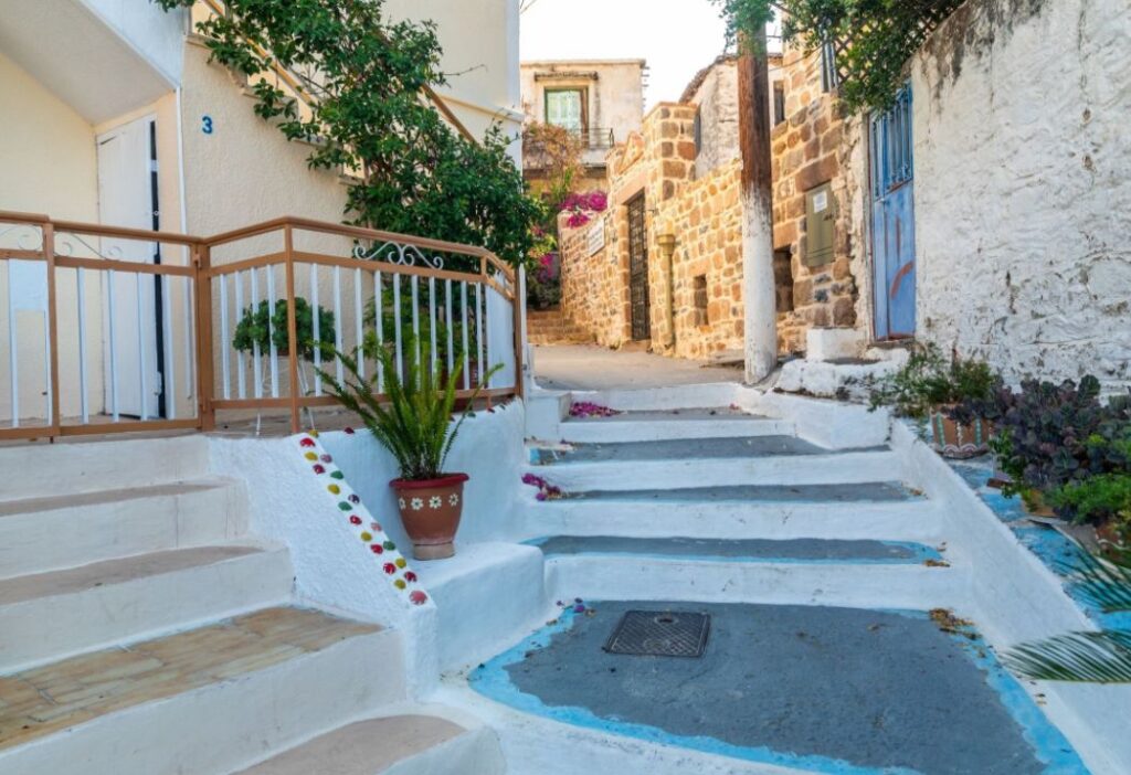 A whitewashed alley with steps with buildings on the sides in Poros Island Greece.