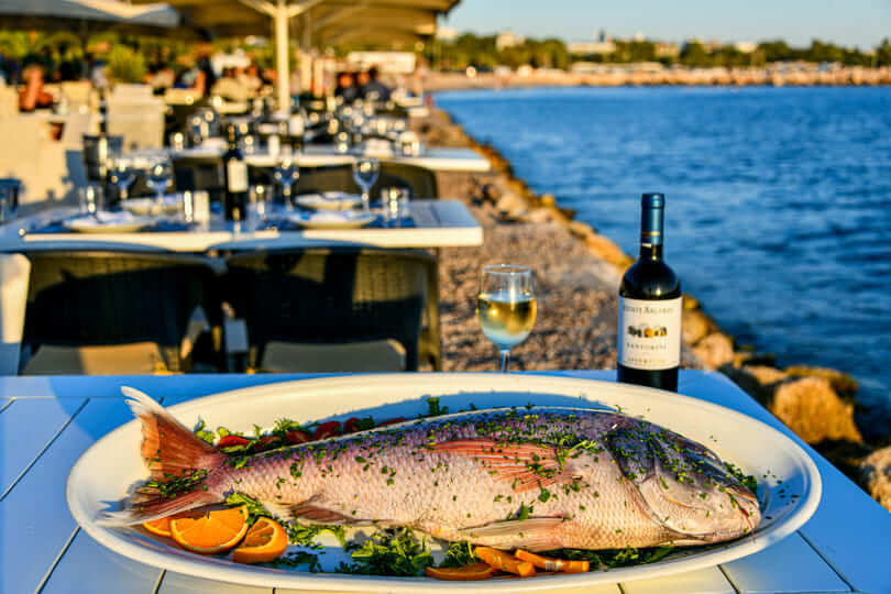 Seaside fish restaurants in Athens:  A dish with fish and wine of Nikolas tis Schinoussas in Athens Greece.