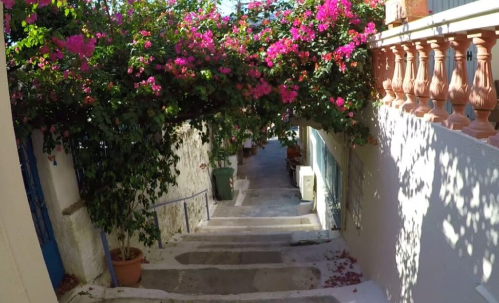 An alley with whitewashed steps and flowers in Poros Island Greece.