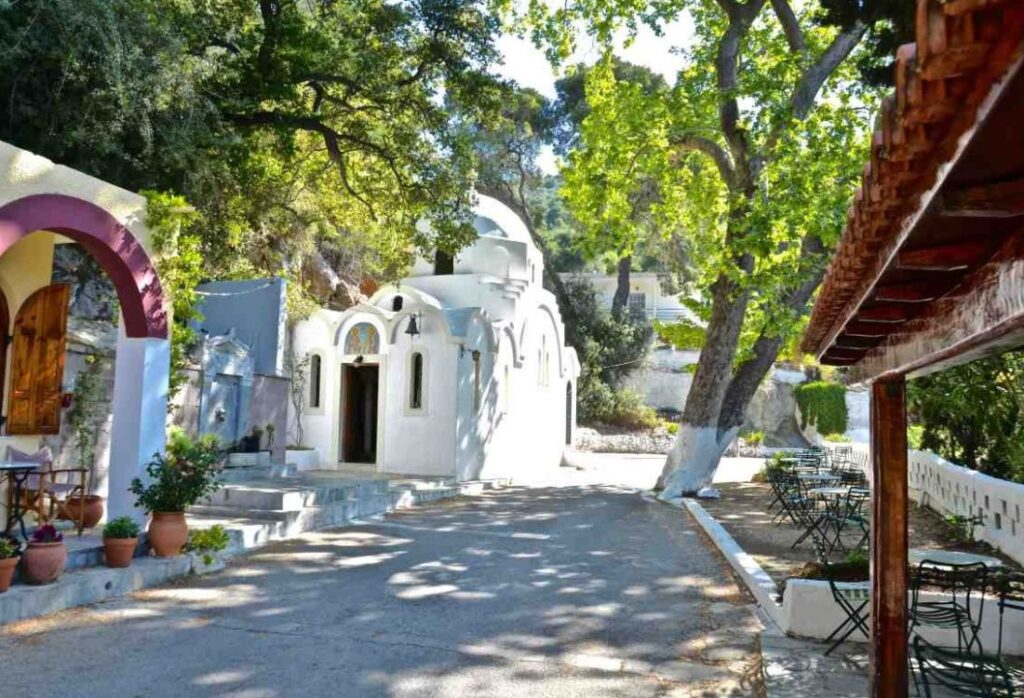 A traditional kafeneio near a whitewashed Greek Church in Poros Island Greece.