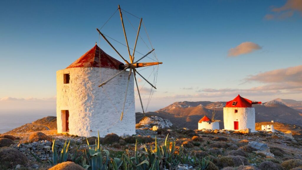 Four Windmills on a top in a sunny day day in Amorgos Island Greece.