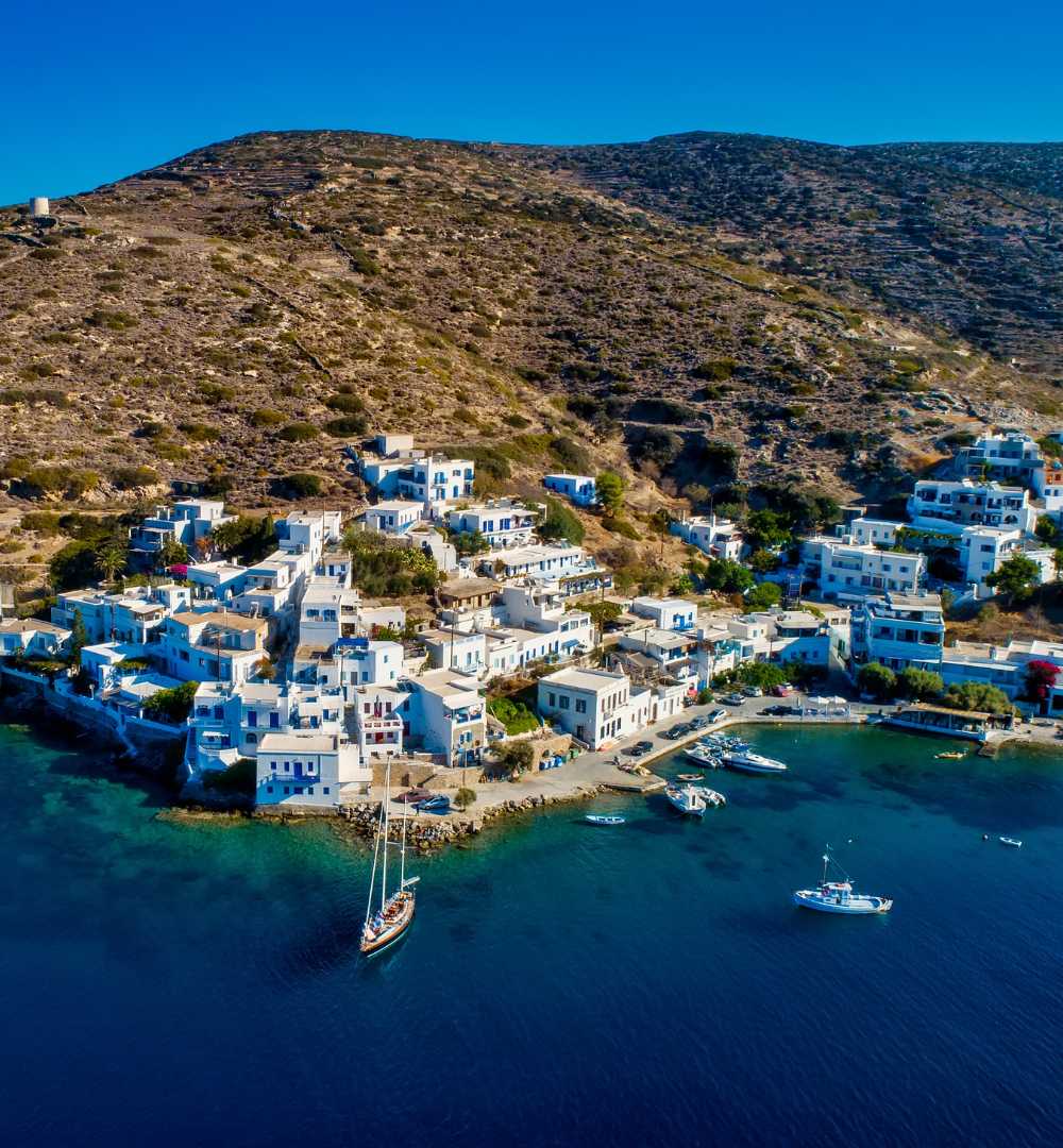 View of Katapola Bay with boats and whitewashed homes, a key stop in an Amorgos travel guide and one of the most charming villages in Amorgos Greece.