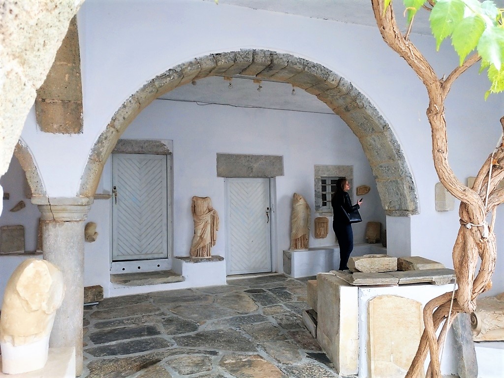 Archaeological Museum and a woman walking out side in Amorgos Island Greece.
