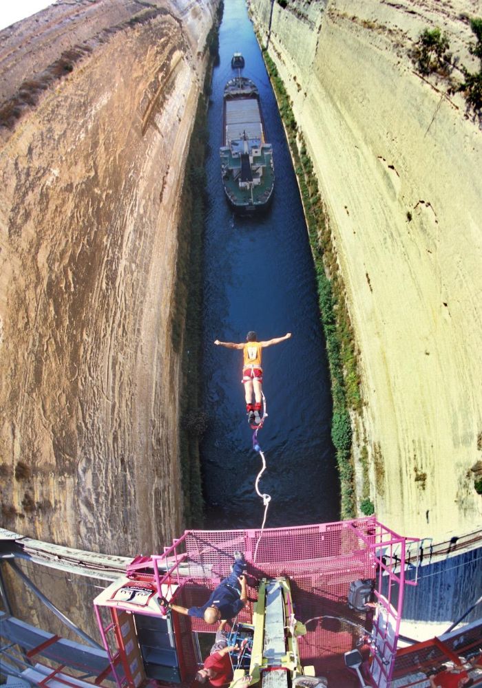 Corinth Canal a boat passing throw and a man doing baddy Jumping in 4 Day Peloponnese.