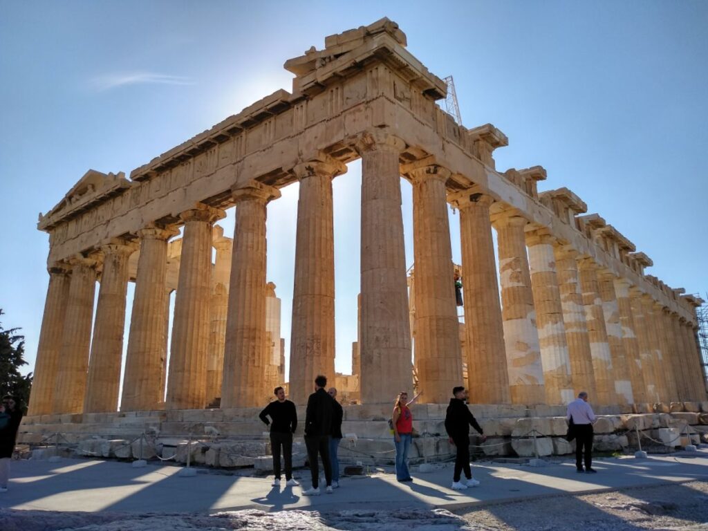 Parthenon Temple and Evgenia in red pointing at the Temple