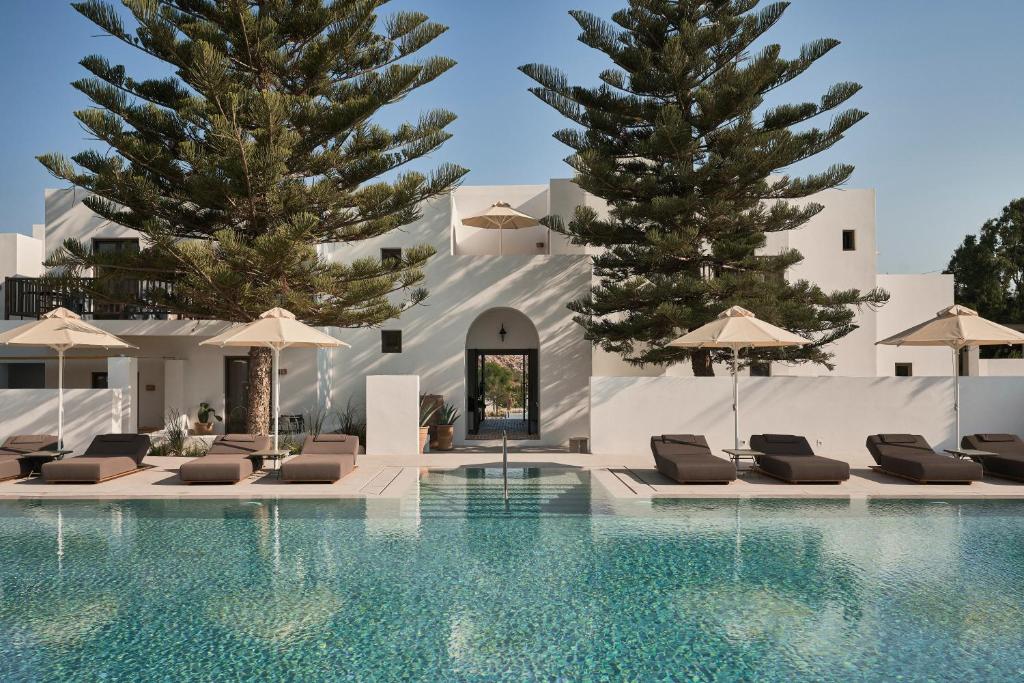 Parilio Hotel in Naoussa with swimming pool and two trees. Paros Greece.