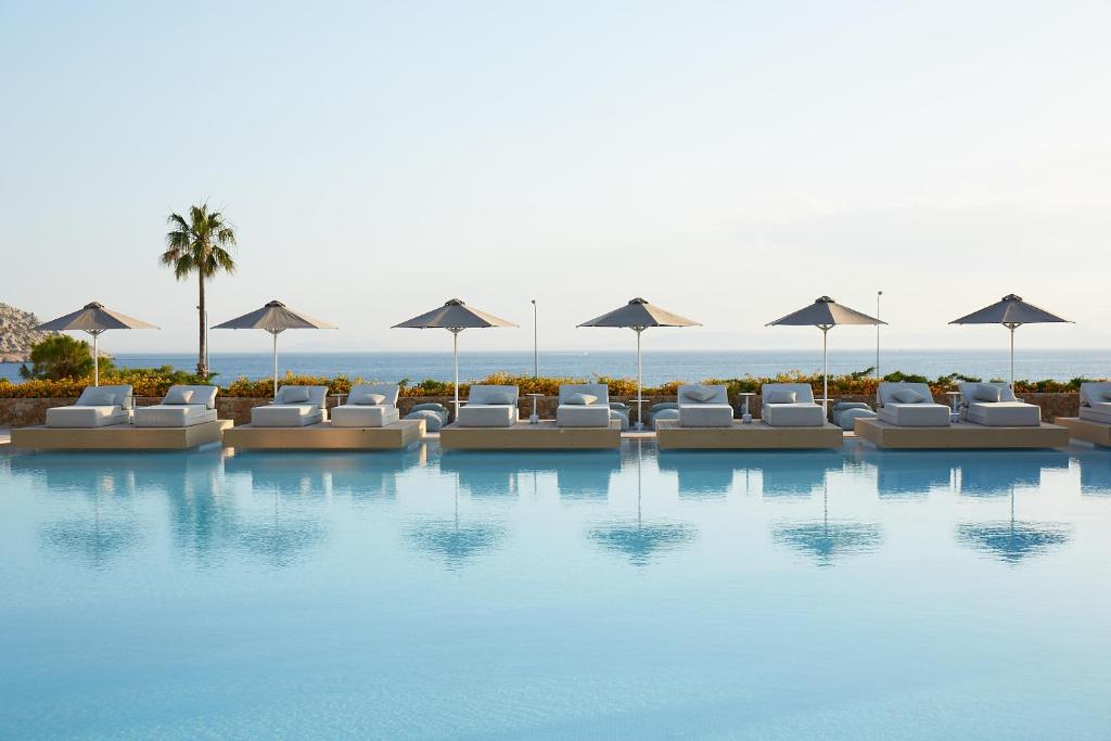 Vincci EverEden Beach Resort in Anavissos Athens Greece with a swimming pool and umbrellas. 