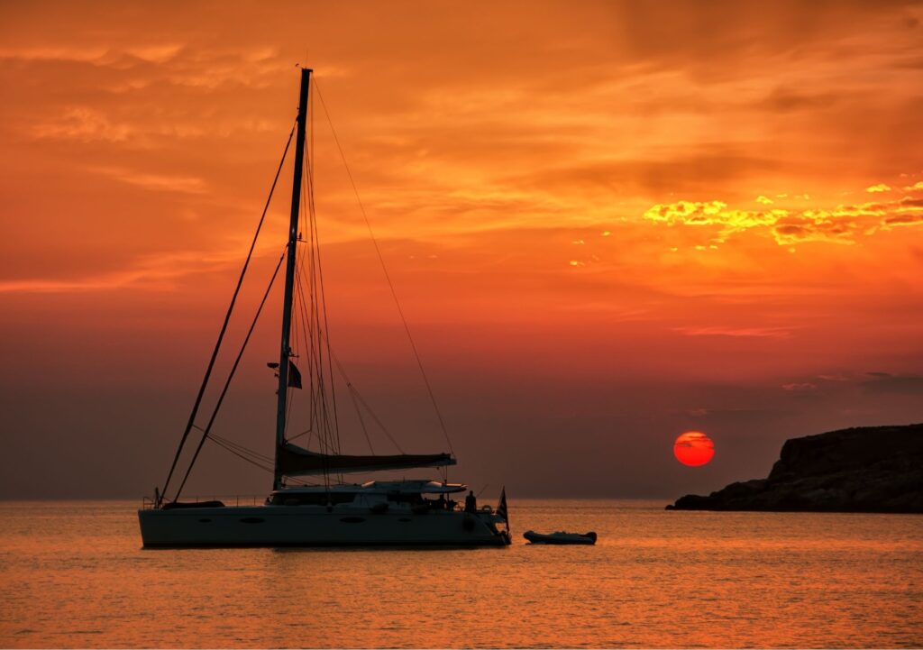 Best things to do in Syros Greece, Sunset in Kini with a yacht