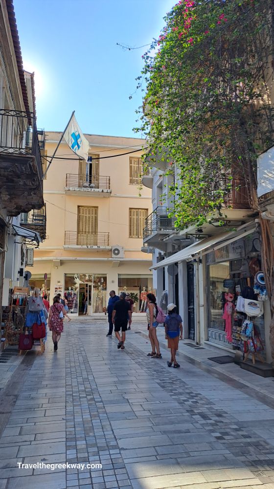 An alley with shops and some people walking. Nafplion.