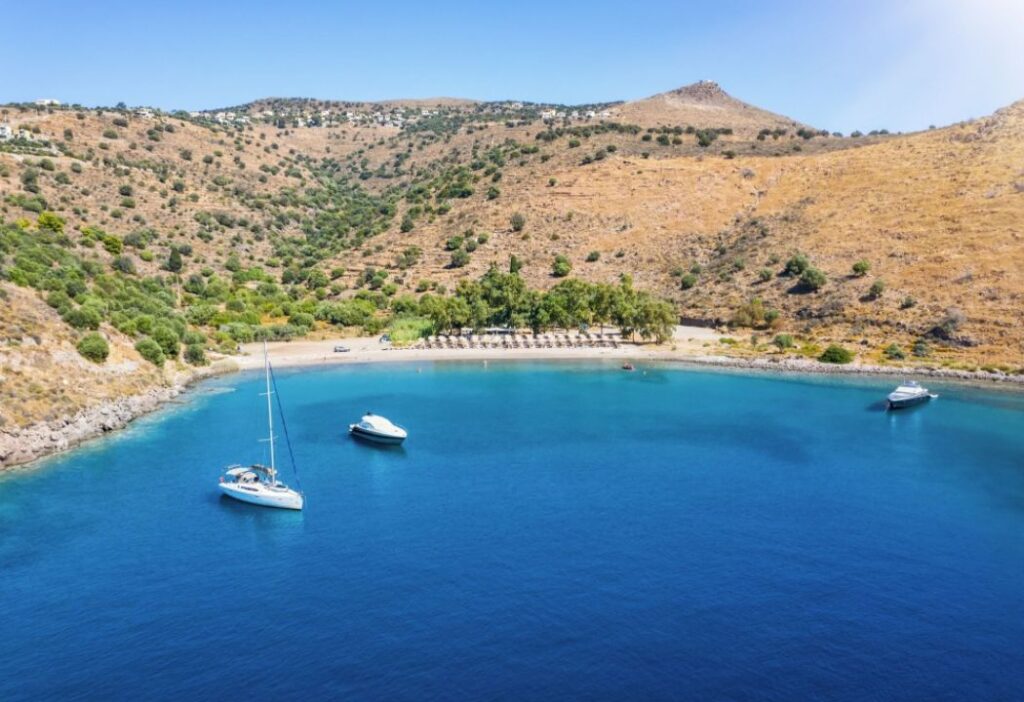 Klima Beach in Aegina island with 3 yachts surronded by hills.