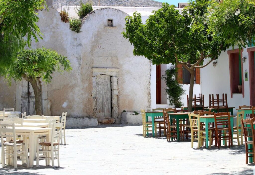 A typical square with tables and chairs in Folegandros Greece.