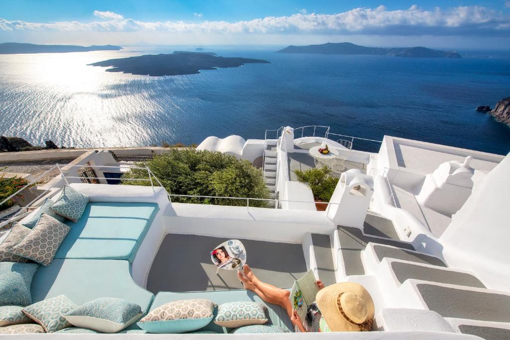 A woman sitting in Amanda Infinity hotel with an impressive caldera view in Santorini. 
