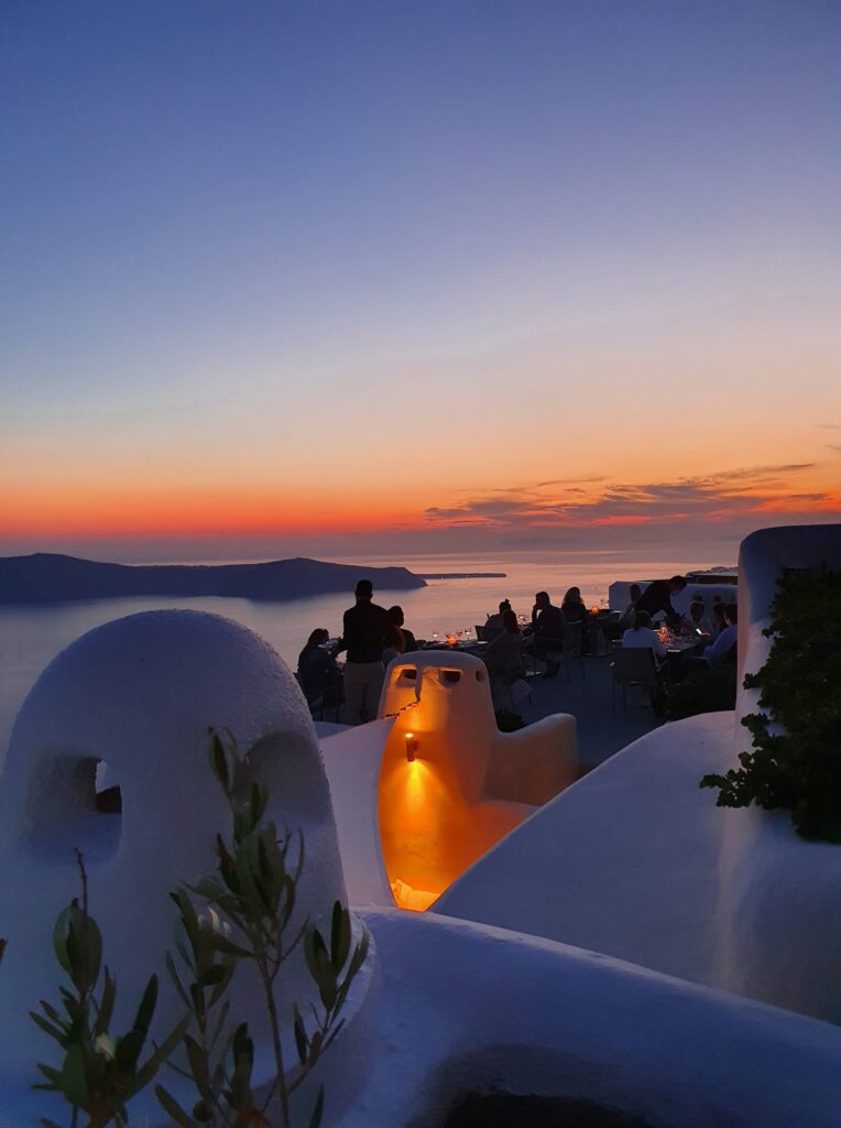 A very impressive Sunset in Santorini with people dining in one of Santorini best diners.