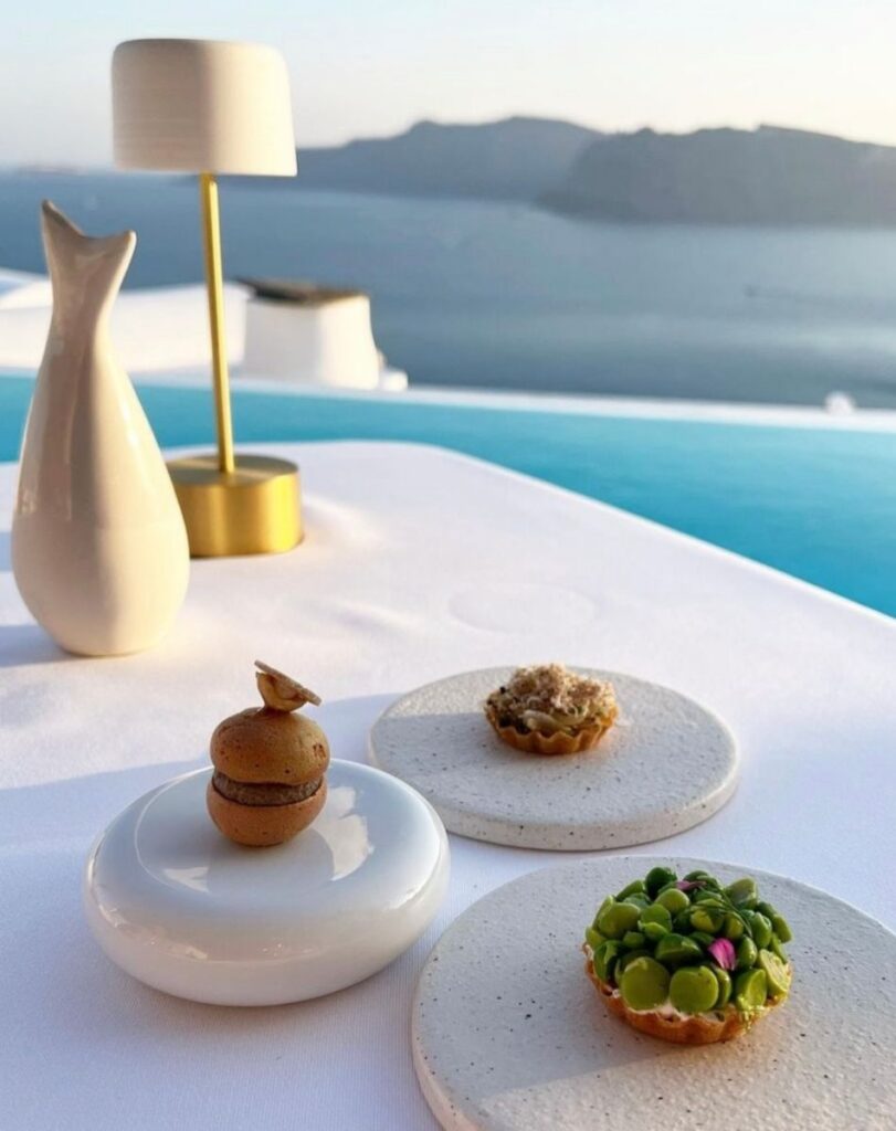  Elegant small plates served with a caldera backdrop, showcasing fine dining in Santorini.