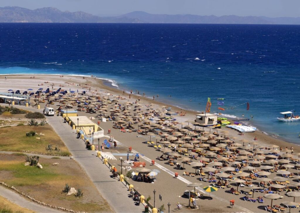 Organized Elli beach with many umbrellas and people under them near Rhodes town.  Rhodes Island.