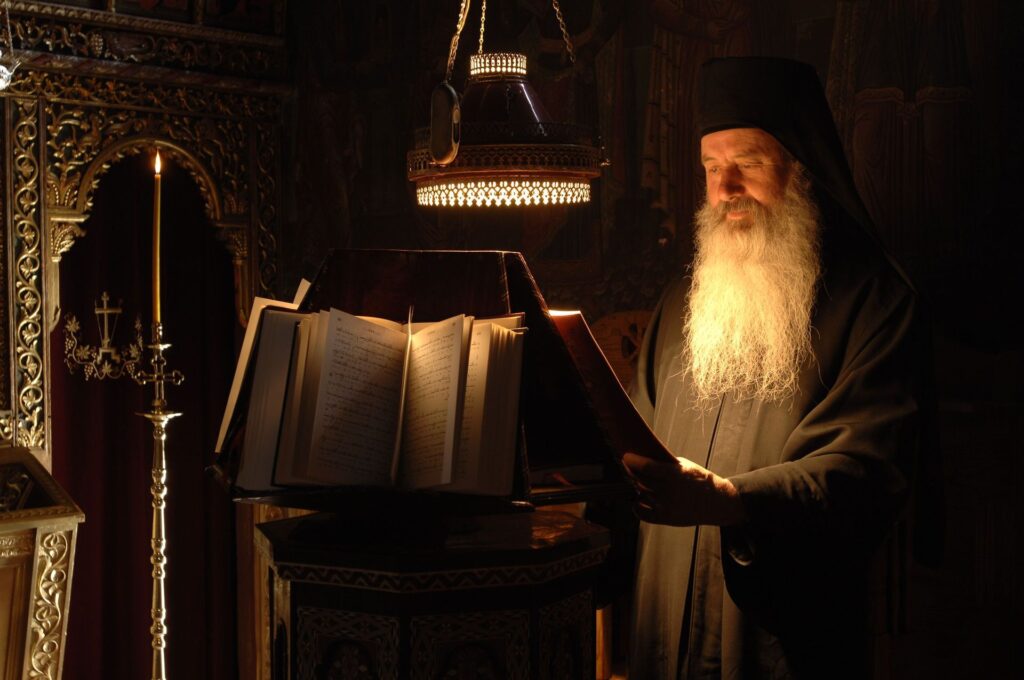 A monk reading at semidarkness. 