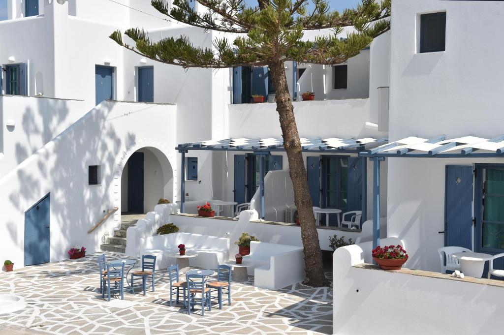 Magginas Studios in Paros Greece and a tree in the yard, tables and chairs. Paros Greece.