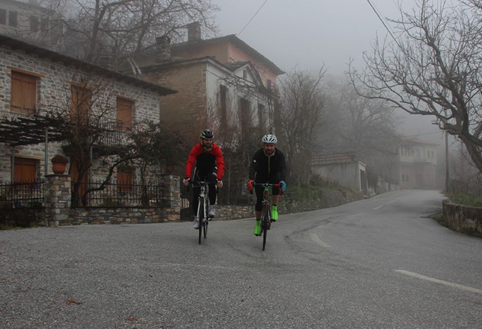 Two bikers on the road with fog.