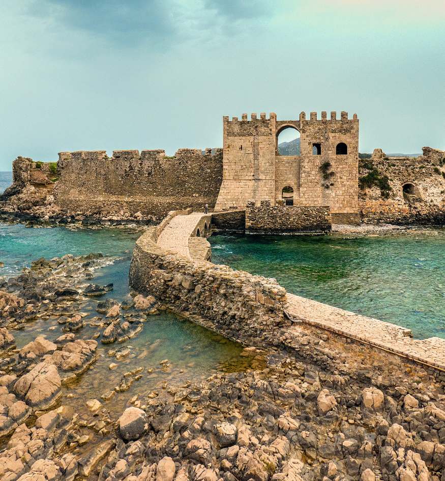 The impressive Bourtzi sea tower of the Methoni Venetian fortress surrounded by the blue Ionian Sea, Greece in April.