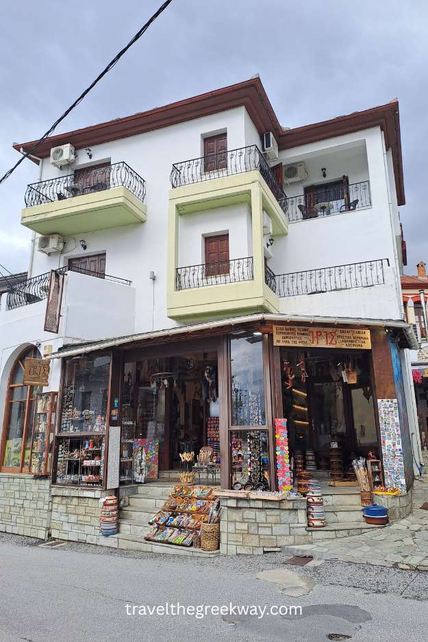 Corner souvenir shop in Portaria with traditional Greek products and colorful items displayed outside.