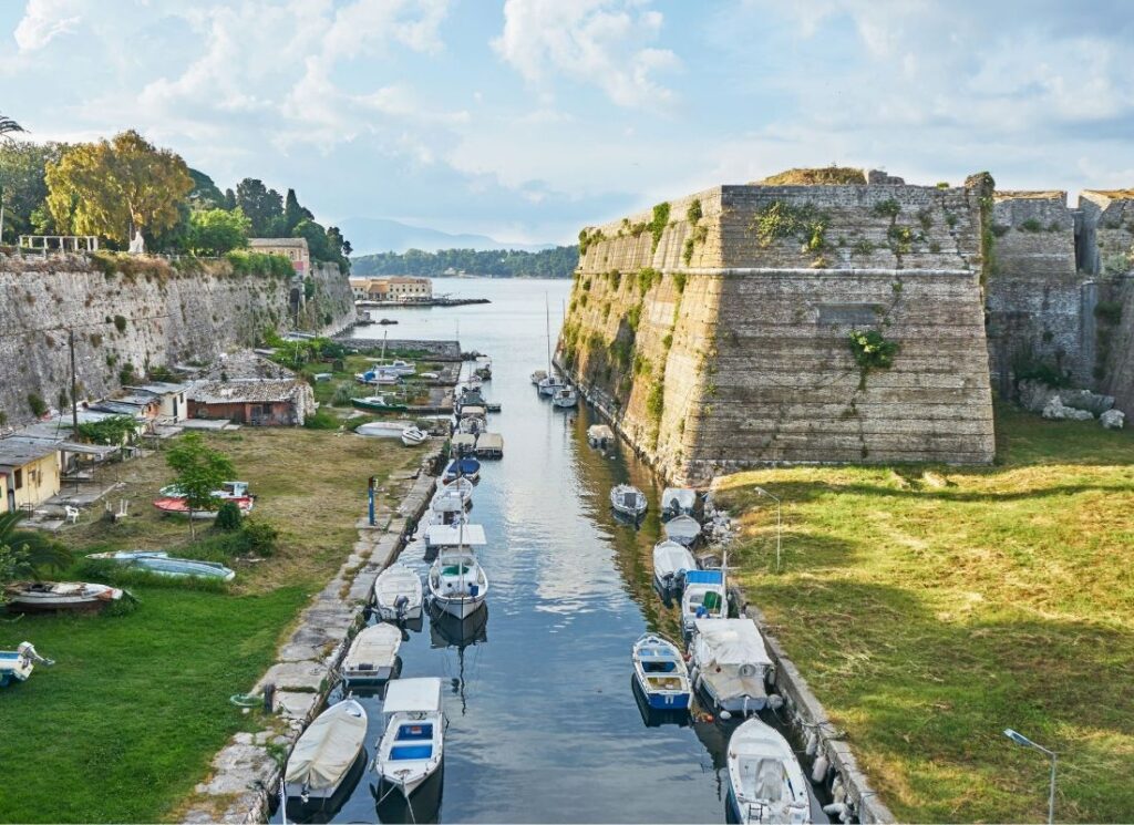 Old Fortress of Corfu with many small boats in the sea. Best things to do on Corfu island.