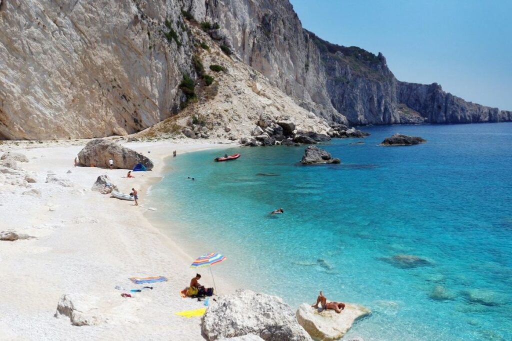 A sandy beach called Diapontia with some people having sunbath.