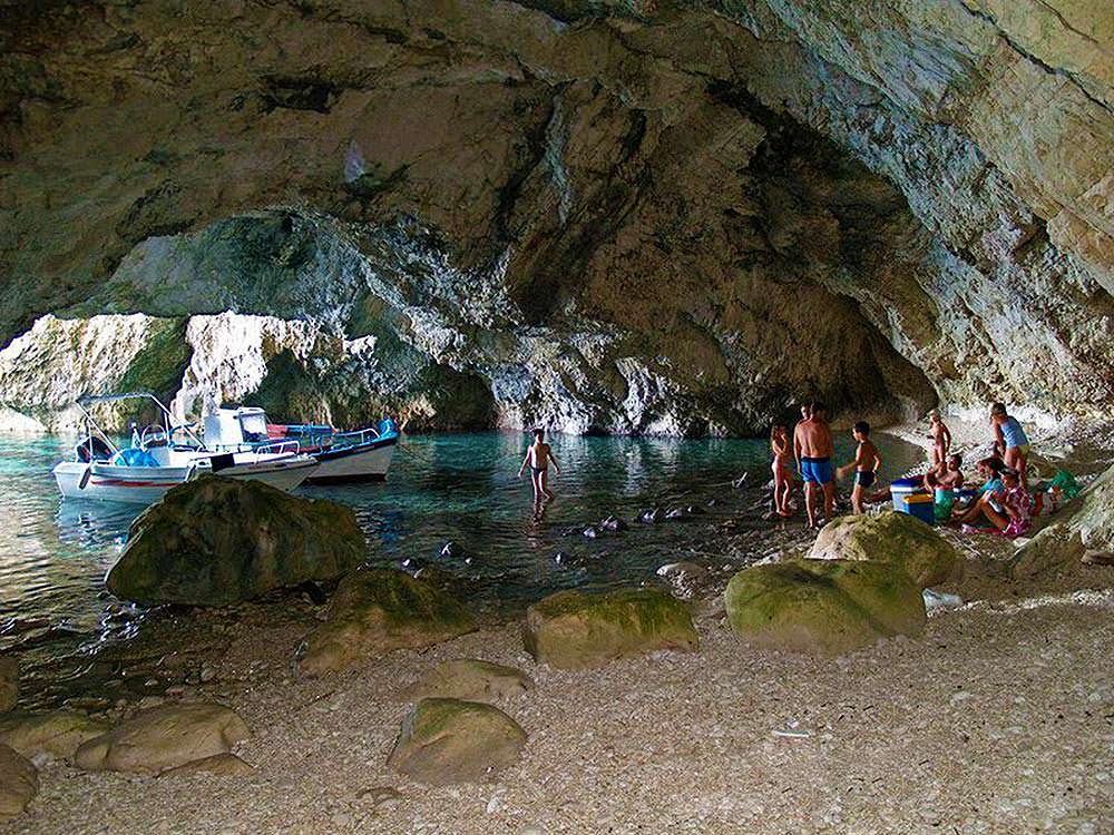  Calypso Cave with some people inside and two small boats in Corfu Island.