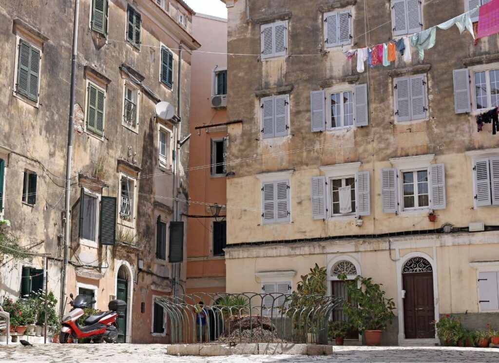  Campielo area with two old buildings and a laundry hanging from a window.Best things to do on Corfu island.  