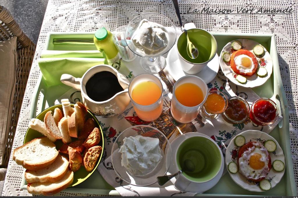 A table fool of breakfast, coffee, fresh orange juice, jam, bread, fried eggs at La Maison Vert Amande.