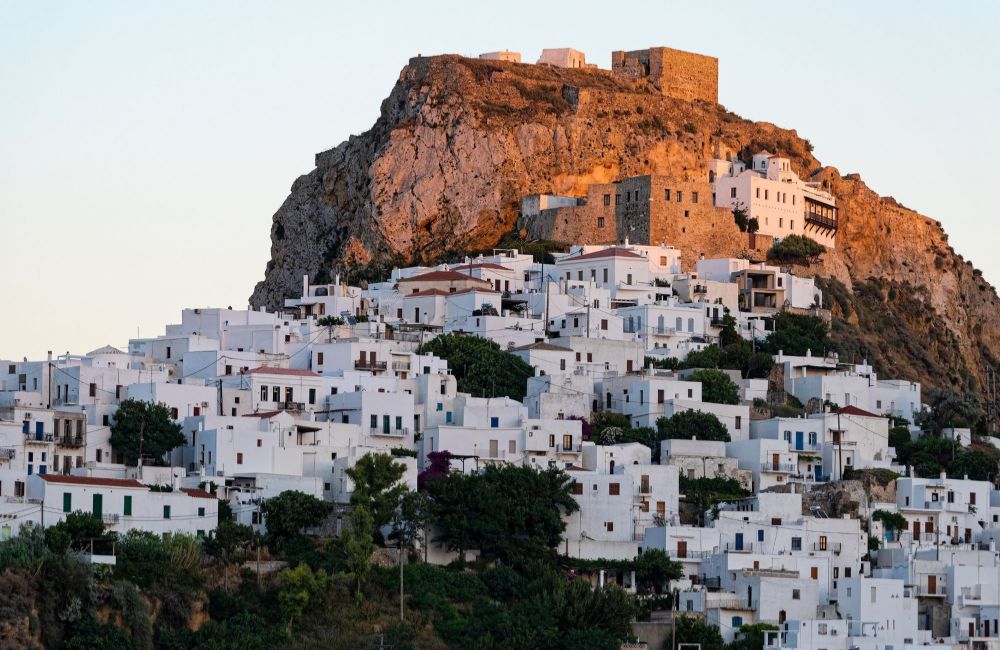 Many whitewashed houses on the cliff and the fortress on the top in Skyros Chora.  